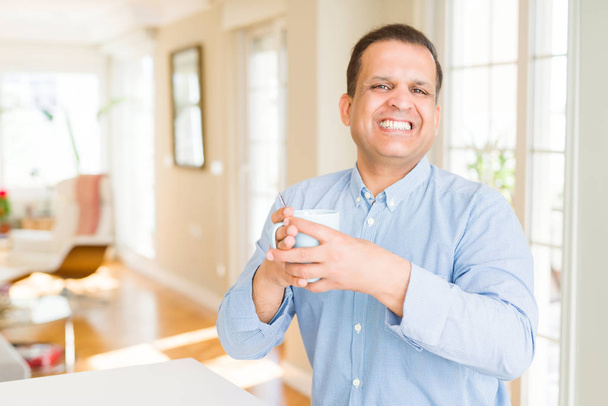 Μέση ηλικία άνθρωπος απολαμβάνοντας και πίνοντας ένα φλιτζάνι καφέ στο σπίτι - Φωτογραφία, εικόνα