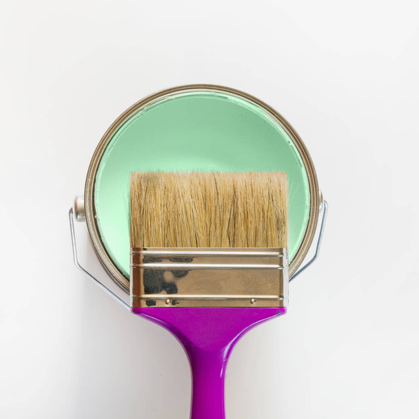 Purple brush with open can of mint paint on white background. Trend concept. - Φωτογραφία, εικόνα
