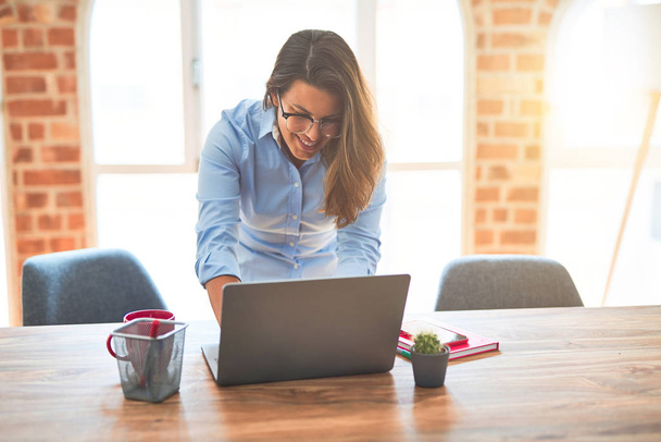 Młoda kobieta biznesu stoi przy biurku pracy przy użyciu laptopa komputerowego, nowoczesna dziewczyna wykonawczy w biurze - Zdjęcie, obraz