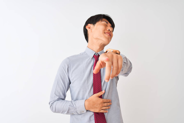 Chinesischer Geschäftsmann mit eleganter Krawatte, der vor isoliertem weißem Hintergrund steht, dich anlacht, mit der Hand über dem Körper in die Kamera zeigt, beschämender Ausdruck - Foto, Bild
