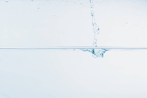 respingo de água perto de respingo de água formando forma isolada no fundo branco
. - Foto, Imagem