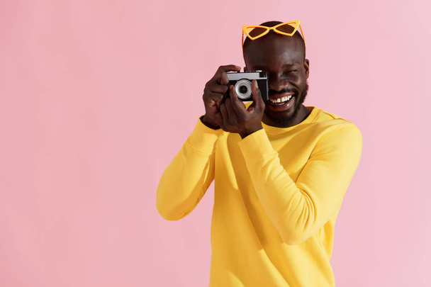 Happy man photographer with photo camera on colorful background - Fotoğraf, Görsel