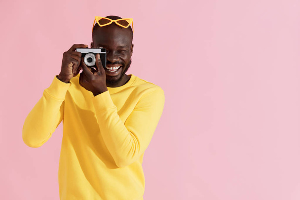 Hombre feliz fotógrafo con cámara de fotos sobre fondo colorido
 - Foto, Imagen
