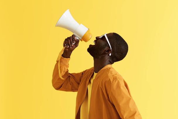 Advertising. Man screaming announcement in megaphone portrait - Foto, Bild