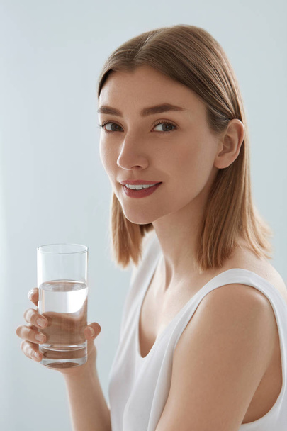 Woman with glass of fresh water in white portrait - Foto, Bild