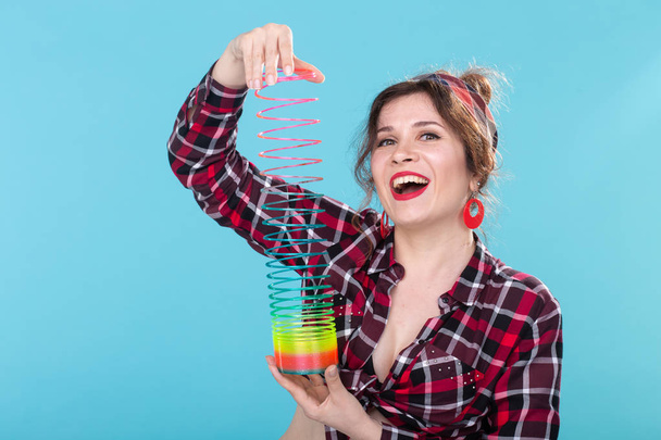 UFA, VENÄJÄ - huhtikuu 2, 2019: pin-up nainen leikkii Slinky sinisellä backgroud
 - Valokuva, kuva