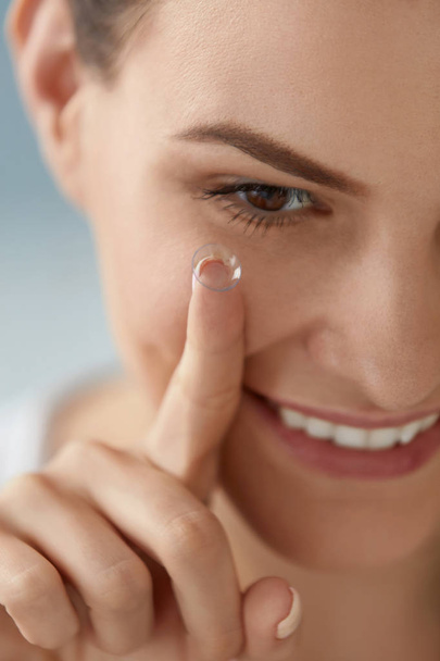 Eye care. Smiling woman with contact eye lens on finger closeup - Foto, immagini