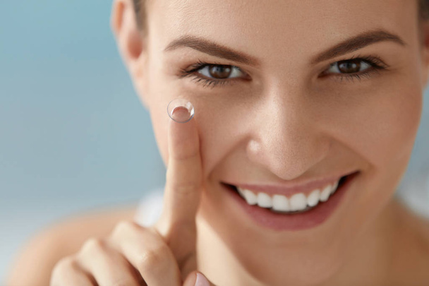 Eye care. Smiling woman with contact eye lens on finger closeup - Фото, зображення