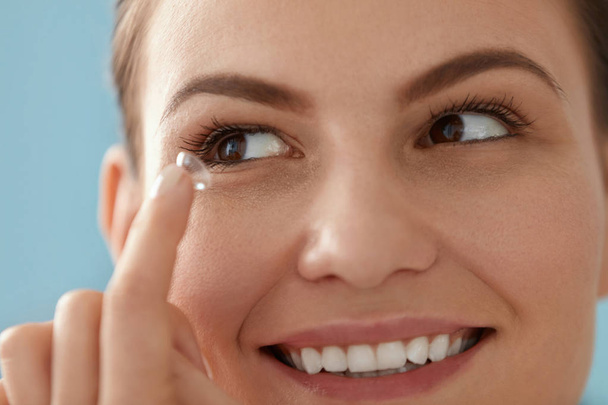 Contact eye lens. Smiling woman applying eye contacts closeup - Foto, afbeelding