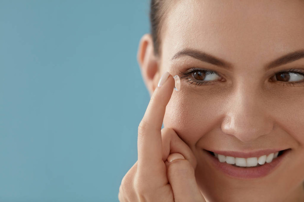 Contact eye lens. Smiling woman applying eye contacts closeup - Фото, зображення