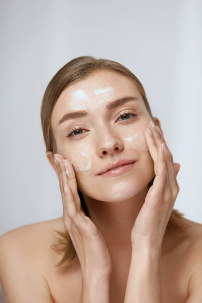 Face skin care. Woman cleaning facial skin with foam soap - Fotó, kép