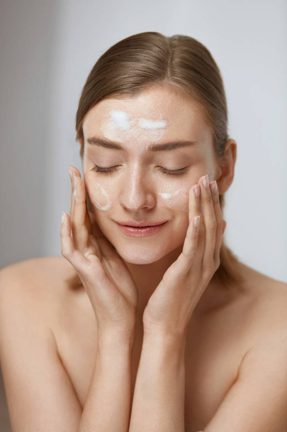 Face skin care. Woman applying facial cleanser on face closeup - Foto, immagini