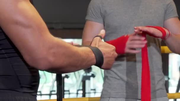 Tiro cortado de dois boxers masculinos embrulhando punhos em ligaduras antes de lutar
 - Filmagem, Vídeo