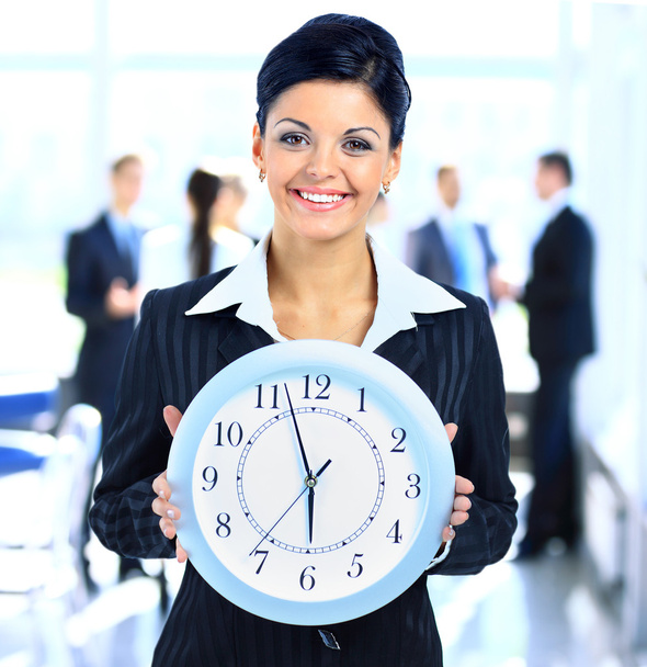 Young attractive business woman holding clock - Фото, изображение
