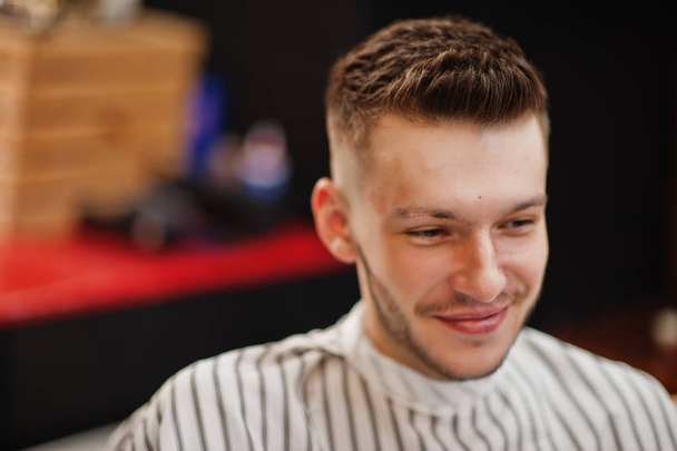 Close up head of young bearded man getting haircut at barbershop - Photo, image