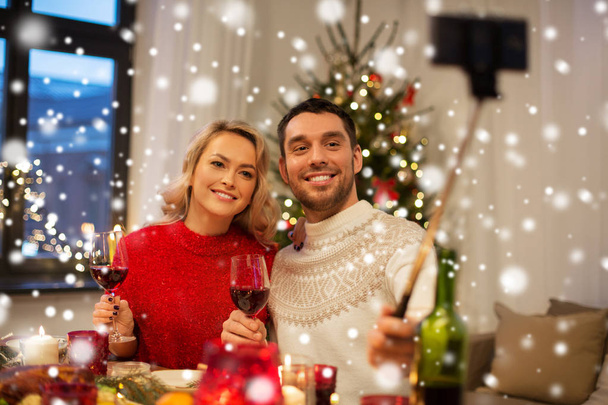 couple taking picture by selfie stick at christmas - Φωτογραφία, εικόνα