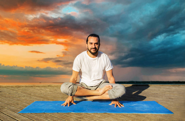 man making yoga in scale pose outdoors - Zdjęcie, obraz
