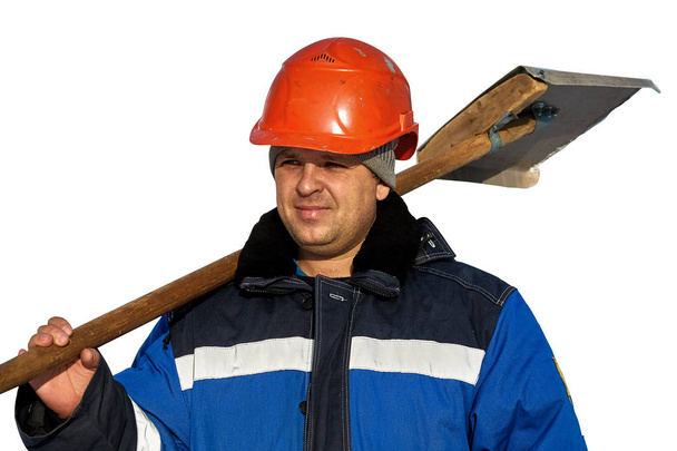 Kışın işçi tulum ve beyaz bir arka plan üzerinde izole omzunda bir kürek ile bir kask. - Fotoğraf, Görsel