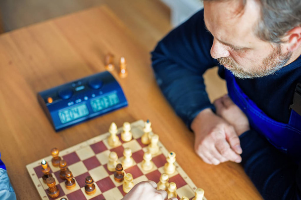 Trabajador juega al ajedrez. Ocio en el trabajo. Vista superior
 - Foto, Imagen