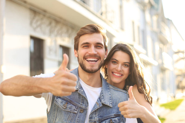 Image of a happy smiling cheerful young couple outdoors take a selfie by camera. - Photo, Image