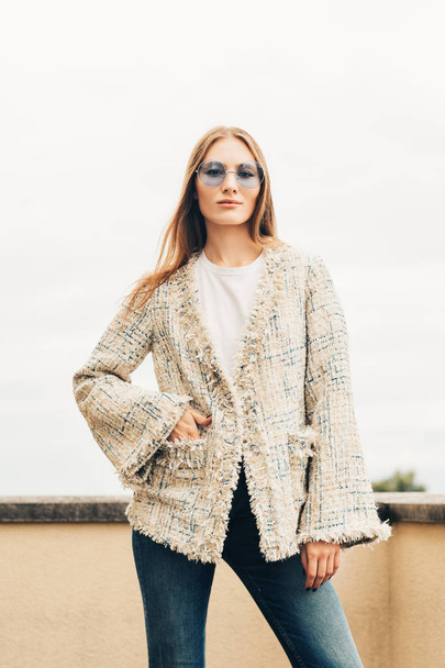 Outdoor Fashion Portret van jonge vrouw dragen stijlvolle jas en denim jeans  - Foto, afbeelding