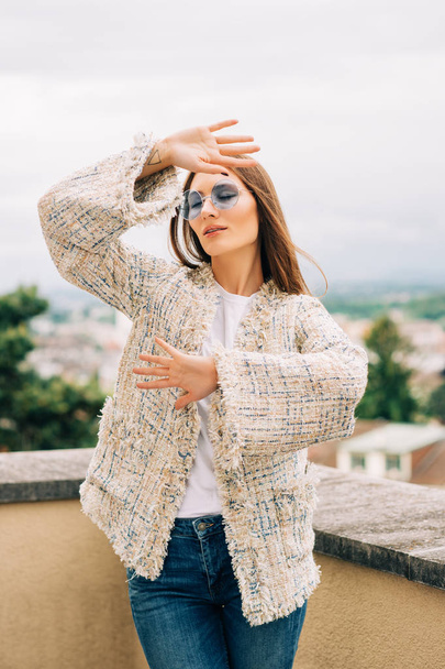 Şık ceket ve kot pantolon giyen genç kadının açık moda portresi  - Fotoğraf, Görsel