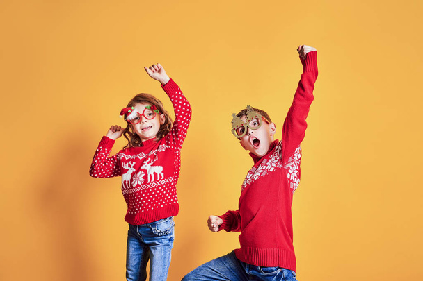 Children in warm red Christmas sweaters - Fotó, kép