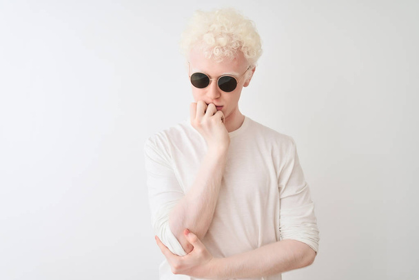 Young albino blond man wearing t-shirt and sunglasses over isolated white background thinking looking tired and bored with depression problems with crossed arms. - Fotografie, Obrázek