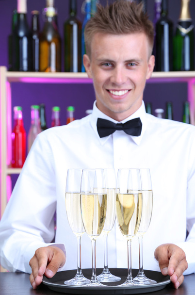 Bartender holding tray with champagne glasses - 写真・画像