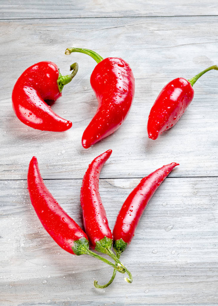 Γλυκές κόκκινες καυτές πιπεριές έξι από αυτές τακτοποιούνται σε επιτραπέζιο - Φωτογραφία, εικόνα