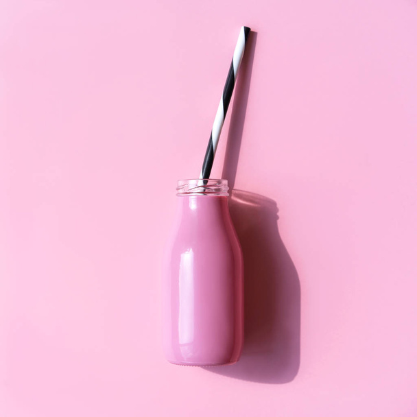 Pink bottle for a drink with a straw on the pink background. - Foto, Bild