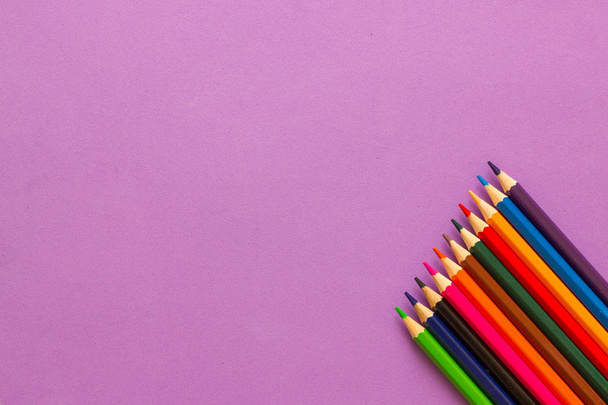 Coleção de lápis coloridos em um fundo roxo vista superior e espaço de cópia. Educação, Regresso à escola. Conceito
 - Foto, Imagem
