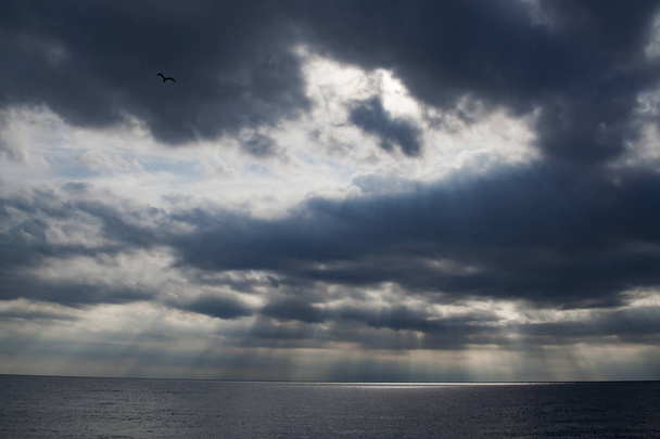 Raggi di sole in nuvole sul mare
 - Foto, immagini