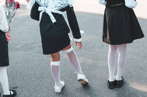 September. beginning of the school year. back view. girl straightens white stockings. - Photo, Image
