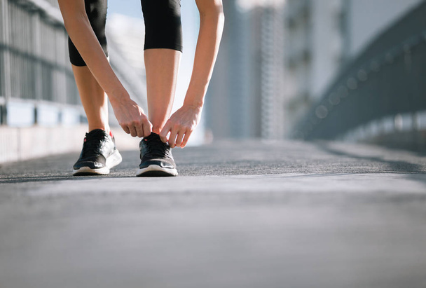 Woman tying her shoes before run. - Fotó, kép