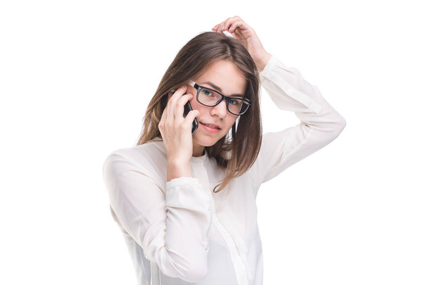 Smiling businesswoman in glasses talking on mobile phone. Beautiful young girl in white shirt on white isolated background talking on mobile phone. Woman in shirt with cellphone. Copy space. Blank - Photo, Image