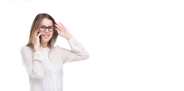 Smiling businesswoman in glasses talking on mobile phone. Beautiful young girl in white shirt on white isolated background talking on mobile phone. Woman in shirt with cellphone. Copy space. Blank - Foto, immagini