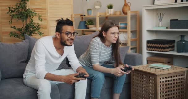 Man and woman happy couple enjoying video game in apartment having fun - Filmagem, Vídeo