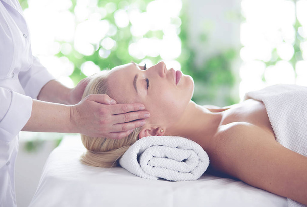 Beautiful woman doing facial massage in a spa salon. - Фото, зображення