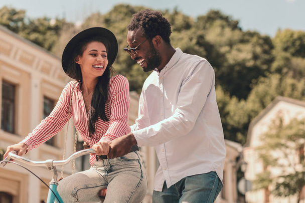 Щаслива пара посміхається, коли жінка їде на велосипеді
 - Фото, зображення