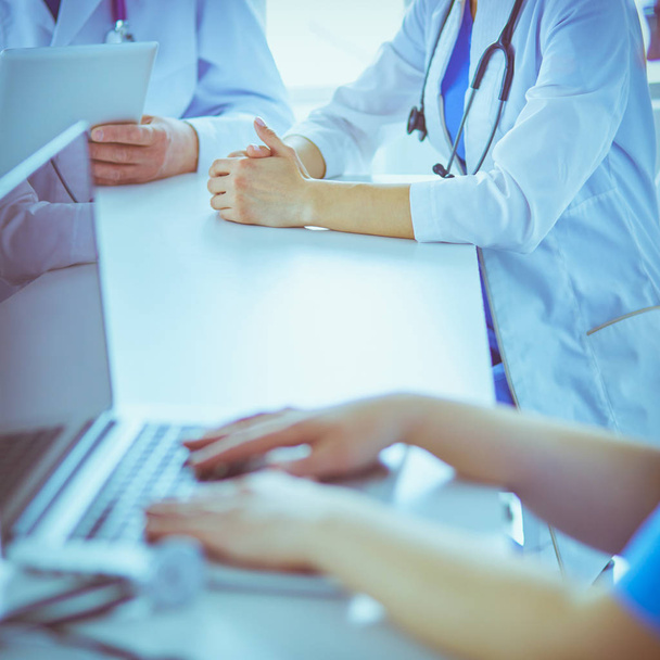 Seriöses medizinisches Team analysiert eine Krankheit eines Patienten in einem hellen Krankenhauszimmer - Foto, Bild
