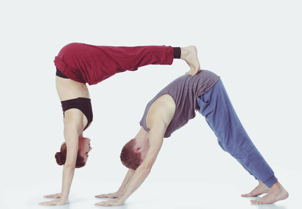 Young athletic couple practicing acroyoga. Balancing in pair. - Foto, Bild