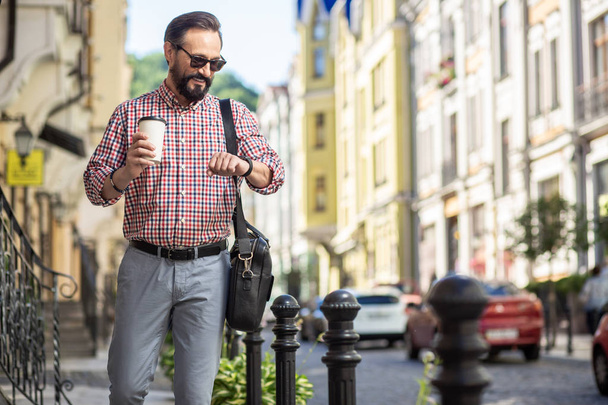 Casual days. Positive adult man smiling while walking along the street - Фото, изображение