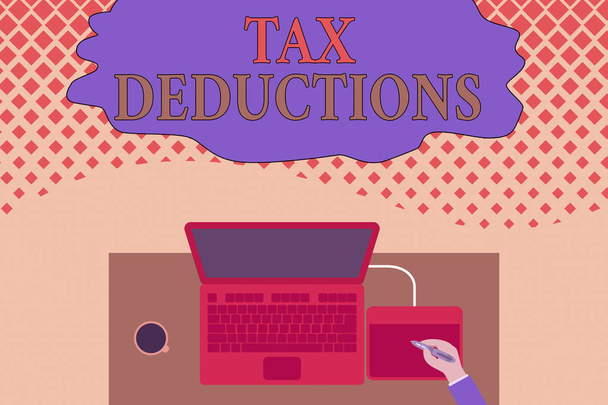 Writing note showing Tax Deductions. Business photo showcasing an amount or cost that subtracted from someone s is income Upper view laptop wooden desk worker drawing tablet coffee cup office. - Photo, Image