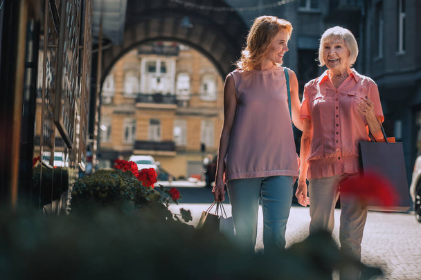 Positive mature woman walking with elderly mother after going shopping. Template banner - Φωτογραφία, εικόνα