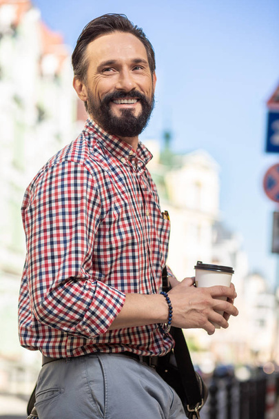 Pleasant walk. Cheerful adult man smiling while going to work along the street - Foto, Bild