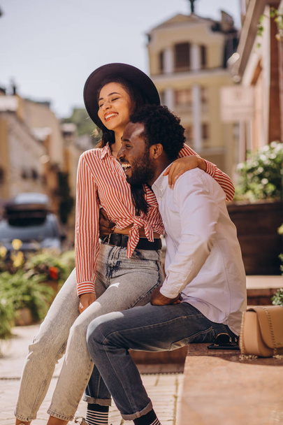 Mirthful young man and woman laughing and hugging outdoors - Photo, image