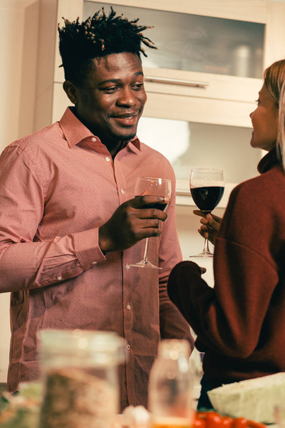 Waist up of friendly cheerful young man standing with a glass of wine with girlfriend and smiling - Fotoğraf, Görsel