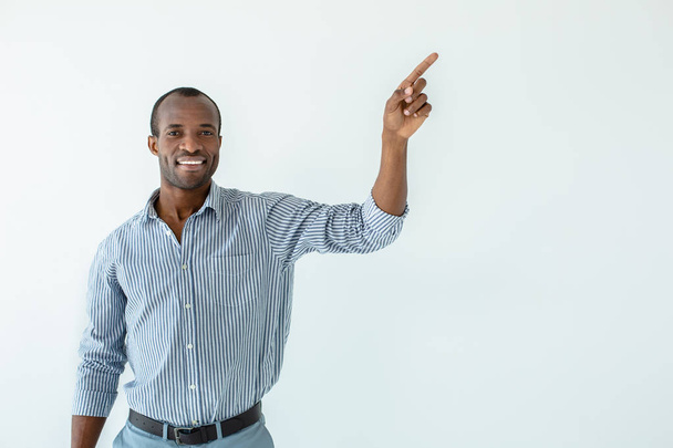 Leadership skills. Cheerful handsome afro american man smiling while pointing aside - Φωτογραφία, εικόνα