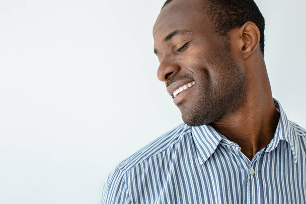 Keep smiling. Close up of joyful afro american man standing against white background - Foto, Imagem